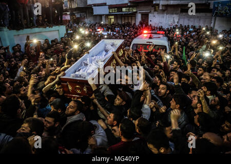 Jabaliya, Gaza. 26 apr, 2018. Lutto palestinese portano una bara contenente il corpo di uno scienziato palestinese Fadi al-Batsh, assassinato in Malaysia, dopo il suo corpo è stato restituito al suo nativo nella Striscia di Gaza il 26 aprile 2018 per il suo funerale nella città di Jabalia, nel nord dell enclave palestinese. Batsh, membro dell'islamista movimento Hamas, è stato ucciso in una pioggia di proiettili in moto-riding aggressori come ha camminato a Kuala Lumpur moschea per Alba preghiere on April 21, 2018 Credit: Nidal Alwaheidi/Pacific Press/Alamy Live News Foto Stock