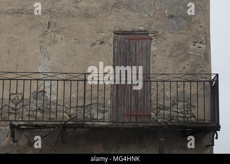 Primo piano con balcone chiuso e la porta di legno in Catllar, villaggio vicino a Prades, Languedoc-Roussillon, Pyrénées-Orientales, Francia. Foto Stock