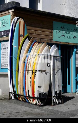 Tavole da surf schierate al di fuori di un negozio a Newquay in Cornovaglia Foto Stock