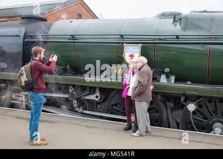 Giovane uomo prendendo una foto del senior, caucasico giovane si fermò insieme sulla piattaforma per annata UK locomotiva a vapore, a Kidderminster's SVR stazione. Foto Stock