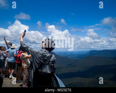 Turistica prendendo selfie a Echo Point Lookout affacciato sulla Jamison Valley, il Parco Nazionale Blue Mountains, Nuovo Galles del Sud, Australia Foto Stock