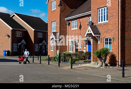 Portalettere consegna la posta in Elvetham Heath, vicino a Fleet, Hampshire, Inghilterra, Regno Unito Foto Stock