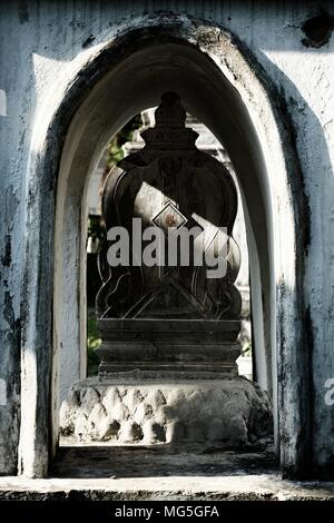 Fascio di luce del sole che splende su antica pietra Heart-Shaped marcatore di confine della Chiesa in tempio thailandese. Foto Stock