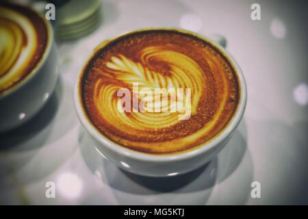 Chiuso il Latte caffè nella tazza bianca. (Fuoco selettivo) Foto Stock