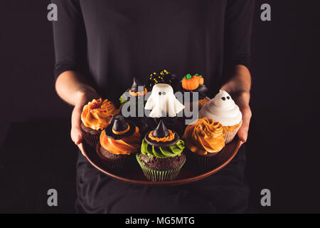 Persona in possesso di halloween tortine Foto Stock