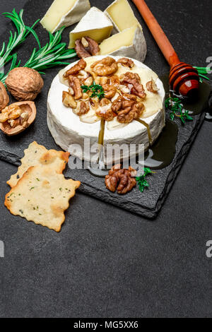 Formaggio Camembert e noci su pietra che serve board Foto Stock