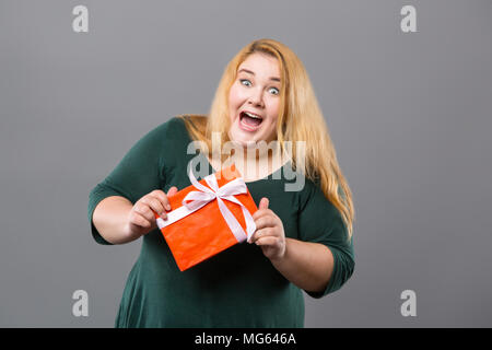 Bella donna emotiva ricevendo un presente Foto Stock