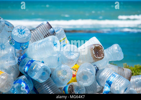 Bottiglie di plastica e di altri rifiuti / inquinamento su una spiaggia in Marocco con il mare in lontananza Foto Stock