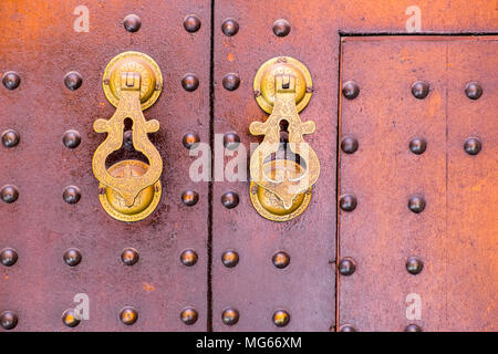 Ornati in ottone maniglie della porta su una porta in Marocco Foto Stock