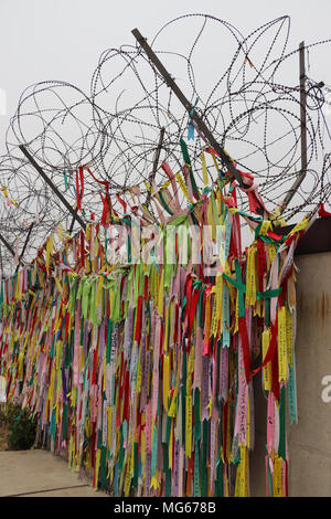 Centinaia di nastri colorati con messaggi di famiglia, i desideri e le speranze di riunificazione, sono appesi alla recinzione al DMZ fra Nord e Sud Corea. Foto Stock
