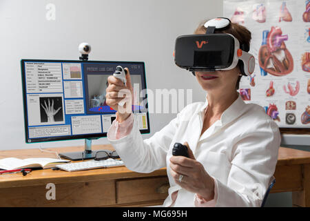 Foto simbolico della telemedicina, un medico di sesso femminile in un ambulatorio medico, con occhiali VR, realtà virtuale, 3-D la visualizzazione di un report di MRI, comunica wit Foto Stock