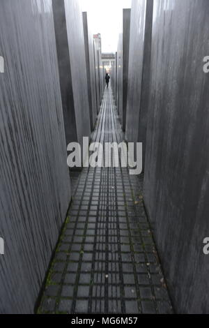 Fugace figura si muove in una sfocatura attraverso il memoriale dell'Olocausto Berlino Germania Foto Stock