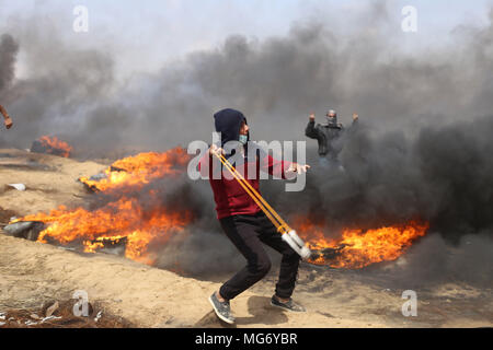 La striscia di Gaza. 27 apr, 2018. Un manifestante palestinese utilizza un slingshot a scaglia pietre alle truppe israeliane durante gli scontri sul confine Gaza-Israel, a est di Khan Younis City, nel sud della striscia di Gaza, il 27 aprile 2018. Credito: Khaled Omar/Xinhua/Alamy Live News Foto Stock