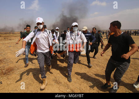 La striscia di Gaza. 27 apr, 2018. I medici palestinesi portano un uomo ferito durante gli scontri con le truppe israeliane sul confine Gaza-Israel, a est di Khan Younis City, nel sud della striscia di Gaza, il 27 aprile 2018. Credito: Khaled Omar/Xinhua/Alamy Live News Foto Stock