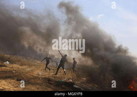 La striscia di Gaza. 27 apr, 2018. Un manifestante palestinese utilizza un slingshot a scaglia pietre alle truppe israeliane durante gli scontri sul confine Gaza-Israel, a est di Khan Younis City, nel sud della striscia di Gaza, il 27 aprile 2018. Credito: Khaled Omar/Xinhua/Alamy Live News Foto Stock