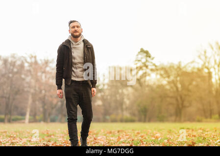 Un bel giovane hipster uomo a camminare nel parco. Foto Stock