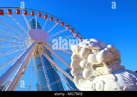 Custode cinese Lion con la Hong Kong ruota di osservazione e la IFC Edificio, Hong Kong, Cina, Sud-est asiatico Foto Stock