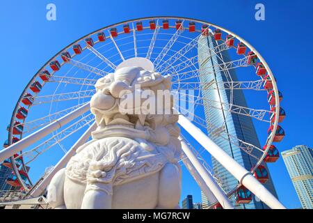 Custode cinese Lion con la Hong Kong ruota di osservazione e la IFC Edificio, Hong Kong, Cina, Sud-est asiatico Foto Stock