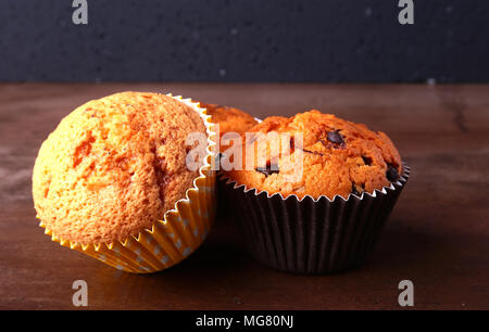 Gustosi tortini di cioccolato, muffin su una bianca tavolo in legno. Foto Stock