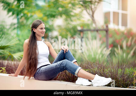 Bella femmina nel parco, bella ragazza adolescente seduti all'aperto e godersi la freschezza della primavera la natura, con piacere trascorrere tranquille weekend outs Foto Stock