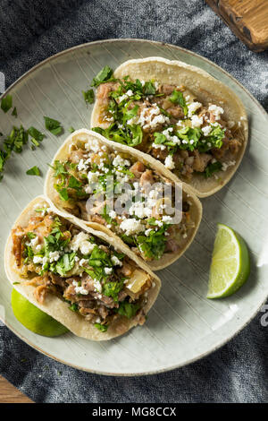 In casa la carne di maiale Carnitas Tacos con il coriandolo e Cojita Foto Stock