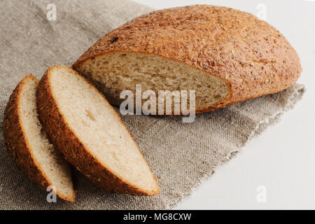 Pane tritata, giace su un letto di sacco su sfondo bianco Foto Stock