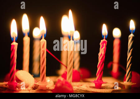 Una torta di festosa, candele bruciano sulla torta. Le candele accese su una torta nel buio Foto Stock