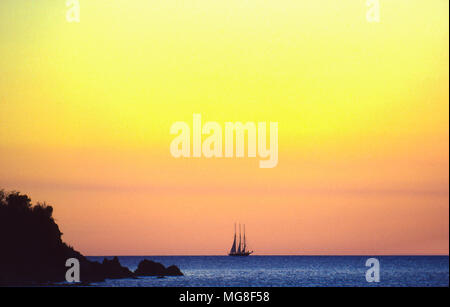 Una tre masted schooner off San Giovanni Isola, U.S. Isole Vergini, crepuscolo. Foto Stock