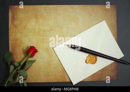 Red Rose giacente sulla carta d'annata per il messaggio Foto Stock
