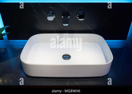 Top bianco lavabo in ceramica e metallo lucido montato a parete miscelatore Foto Stock