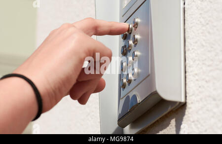 Valore numerico della porta del dispositivo di codifica sull'edificio, con mano femmina tenendo premuto i pulsanti Foto Stock