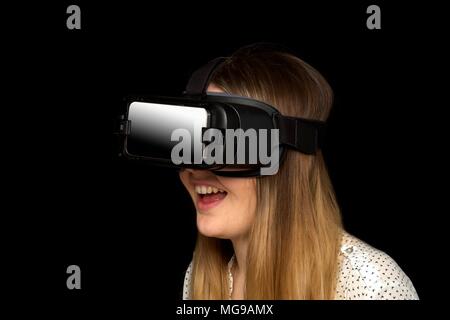 Giovane donna che indossa la realtà virtuale auricolare, studio shot. Foto Stock