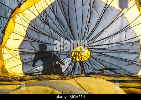 Silhouette di un crewman all'interno di un gonfiaggio retroilluminato in mongolfiera ad aria calda Foto Stock