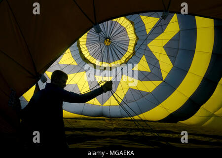 Silhouette di un crewman all'interno di un gonfiaggio retroilluminato in mongolfiera ad aria calda Foto Stock