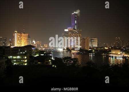 Skyline della città di notte sopra il fiume Chao Phraya con skyscrappers illuminato, Bangkok, Thailandia. Foto Stock