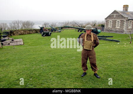 Colchester, Regno Unito - 12 Aprile 2018: militare storico vestito di WW2 Royal Artillery sergente uniforme, spiegare i pezzi di artiglieria abou Foto Stock