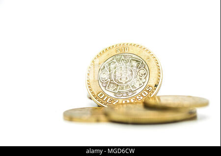 Pila di monete, peso messicano di denaro solido su sfondo bianco. Foto Stock