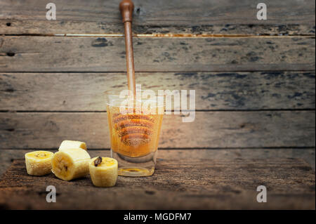 Miele e banana , legno sfondo vintage Foto Stock