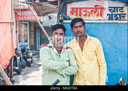 Aurangabad, INDIA-Dec, 30 2016: due indiani la felicità degli uomini in camicia verde e giallo shirt in piedi davanti a sfondo blu a Gul Mandi mercato locale Foto Stock