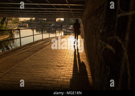 Camminando lungo la strada alzaia del Regents Canal come il sole tramonta su una sera d'estate Foto Stock