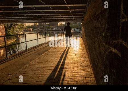 Camminando lungo la strada alzaia del Regents Canal come il sole tramonta su una sera d'estate Foto Stock