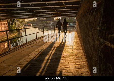 Camminando lungo la strada alzaia del Regents Canal come il sole tramonta su una sera d'estate Foto Stock