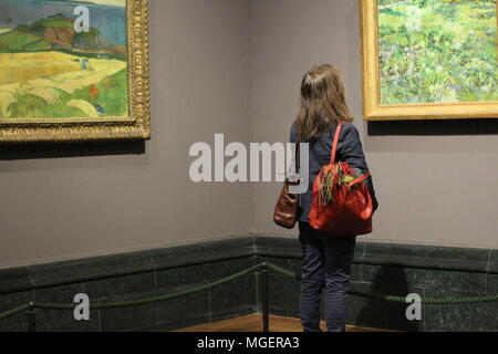 Una donna intenta a ammirando un dipinto di fronte ad esso in un museo Foto Stock