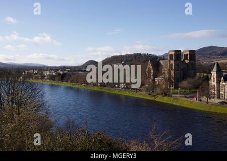 Una cattedrale in Inverness corre lungo la città scozzese fiume in una giornata di sole con il blu del cielo e il verde degli alberi in primo piano Foto Stock