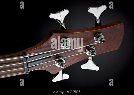 Close-up studio shot di maroon bass guitar scorta testa su sfondo nero Foto Stock