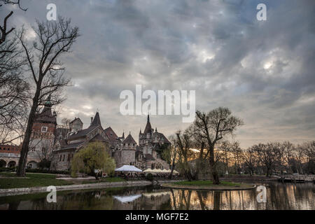 Castello di Vajdahunyad di fronte ad un lago nel Parco Varosliget (parco della città) di Budapest, Ungheria. Situato vicino al bagno termale Széchenyi, è uno dei principali monu Foto Stock