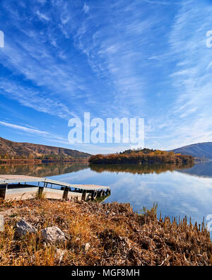 Vista tranquilla del lago Eymir in Ankara Turchia compreso un isolotto coperto con alberi e un molo nella primavera sunrise Foto Stock