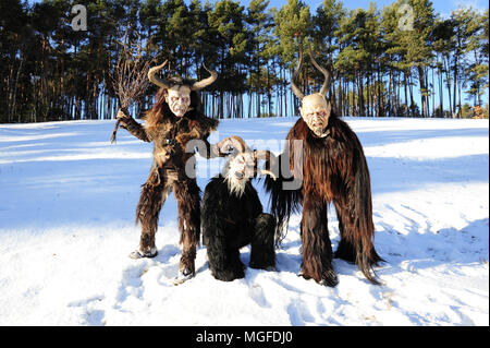 Tre Krampus figure nella campagna vicino alla città di Castelrotto (Castelrotto), Alto Adige, Italia Foto Stock