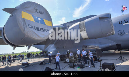 28 aprile 2018, Germania, Schoenefeld: una fascia giocare sotto l'ala di un US Air Force Boeing C-17 Globemaster durante la ILA 2018. Circa 200 aerei vengono presentati durante la ILA 2018 internazionale salone aeronautico. Gli organizzatori si aspettano circa 150.000 visitatori. La Ila avviene tra 25 e 29 aprile 2018. Foto: Patrick Pleul/dpa-Zentralbild/dpa Foto Stock