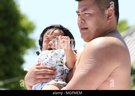 Tokyo, Giappone. 28 apr, 2018. Un bambino tenuto da un dilettante lottatore di sumo grida durante il 'baby-cry sumo' concorrenza presso il tempio di Sensoji di Tokyo il Sabato, 28 aprile 2018. Giapponese i genitori credono che lottatori di sumo possono contribuire a rendere i bambini gridano il desiderio di crescere con un buono stato di salute. Credito: Yoshio Tsunoda/AFLO/Alamy Live News Foto Stock